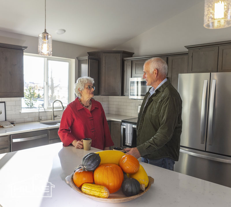 Image of older couple drinking coffee in their HiLine Home kitchen.